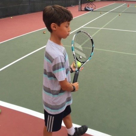 Young tennis player holding a racket on court