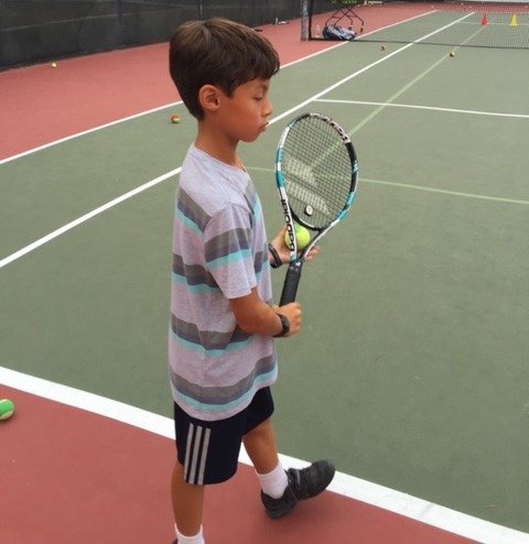 Junior tennis player preparing in a ready position
