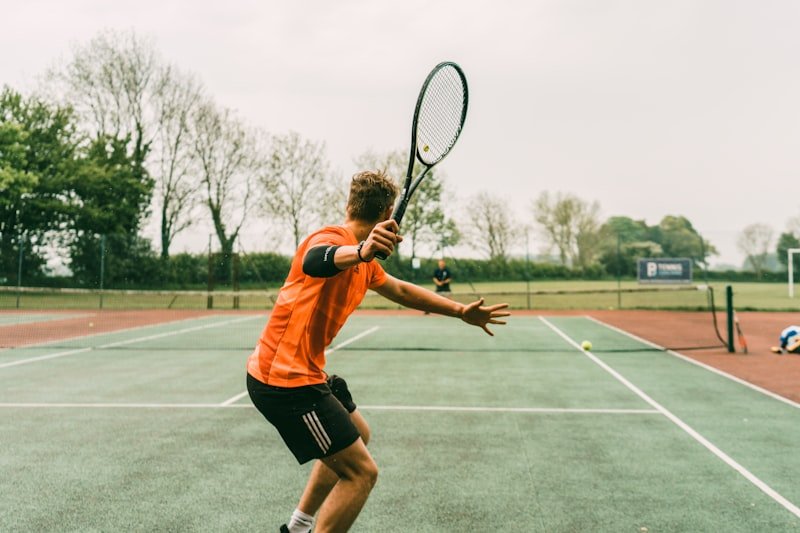 Tennis player driving a forehand during a private lesson on an outdoor court