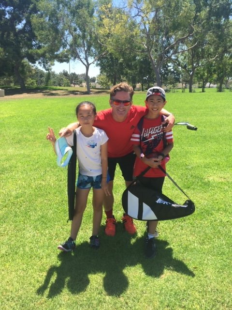 Jimmy Gleason with junior tennis players on court